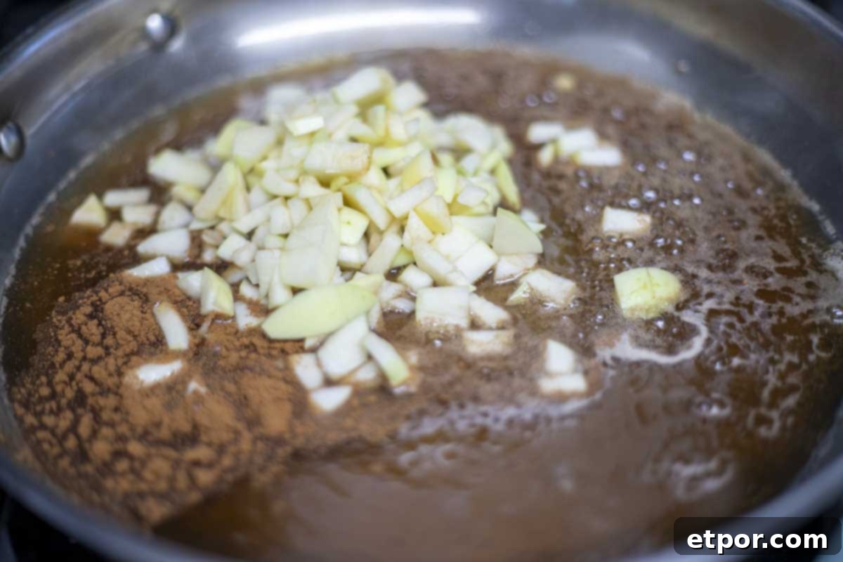 apples added to sugar, water, and cinnamon mixture.