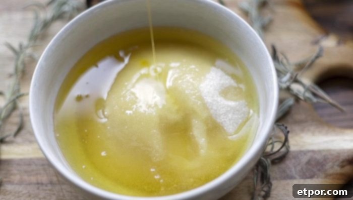 adding olive to sugar in a white bowl on a wood cutting board