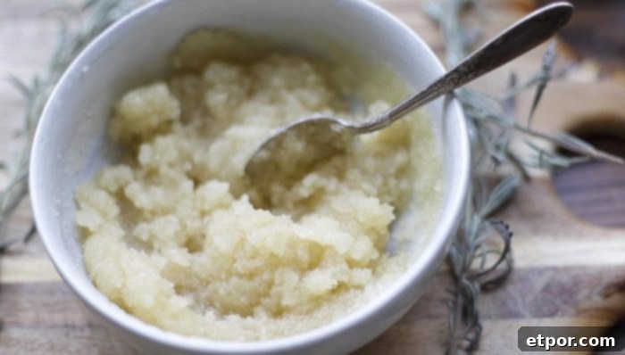 sugar scrub being mixed together in a white bowl on a wood cutting board
