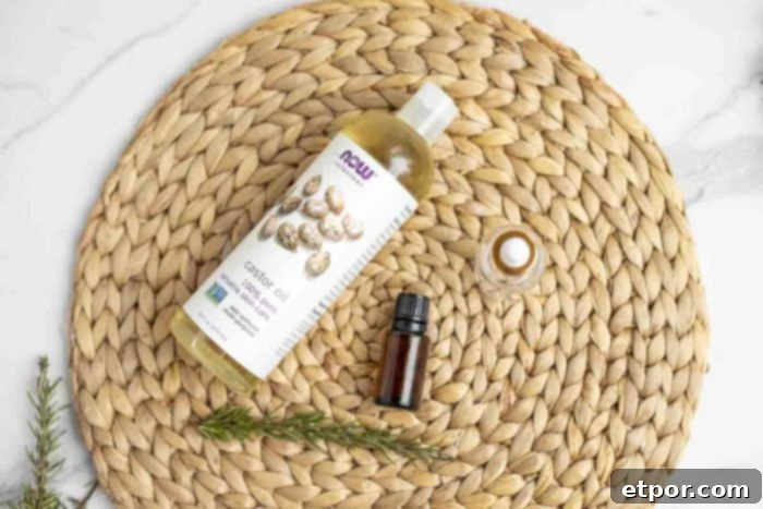 Boost Hair Growth with Homemade Rosemary Oil 6 castor oil, rosemary essential oil, and a sprig of rosemary on a woven placemat