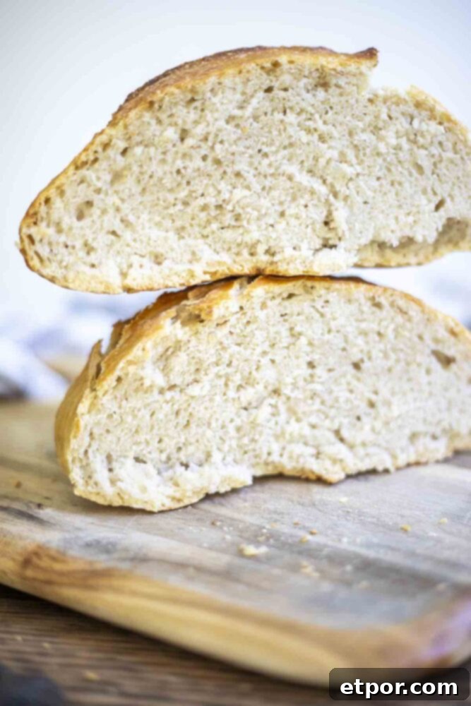 two halves of sourdough discard bread stacked on top of each other on a wood cutting board
