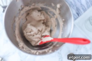 The Secret to Unforgettable Chocolate Whipped Cream 8 chocolate whipped cream in a silver bowl with a red spatula