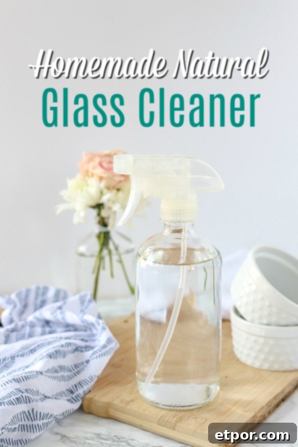 natural DIY glass cleaner in a glass bottle on a wood cutting board with a blue and white napkin and jars behind it
