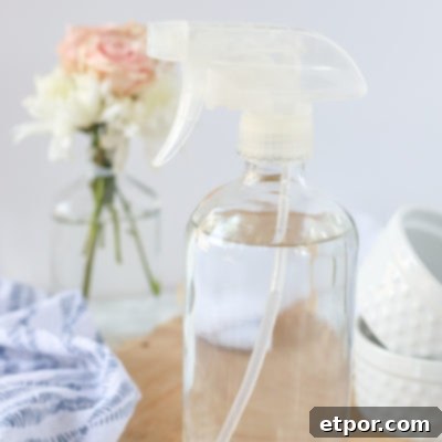 DIY glass cleaner in a glass bottle on a wood cutting board