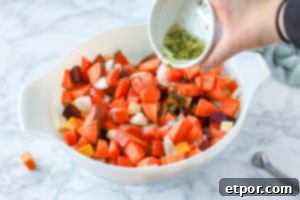 Rustic Roasted Root Vegetables 8 adding oil, herbs and garlic to a bowl of root vegetables for roasted root vegetable recipe