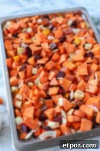 Rustic Roasted Root Vegetables 10 root vegetables on a parchment lined sheet pan getting ready for roasting
