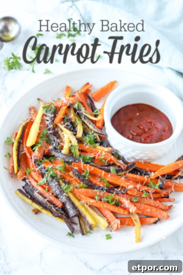 colorful baked carrot fries sprinkled with parsley and cheese on a white plate with ketchup 