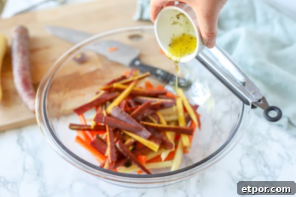 sliced carrots in a glass bowl with oil and herbs being poured on top
