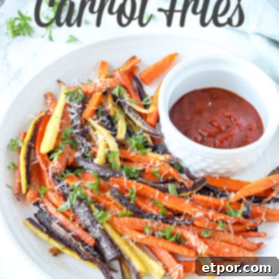 colorful baked carrot fries sprinkled with parsley and cheese on a white plate with ketchup