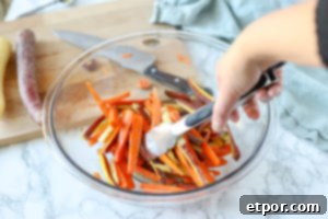 tossing oil into sliced carrots in a glass bowl
