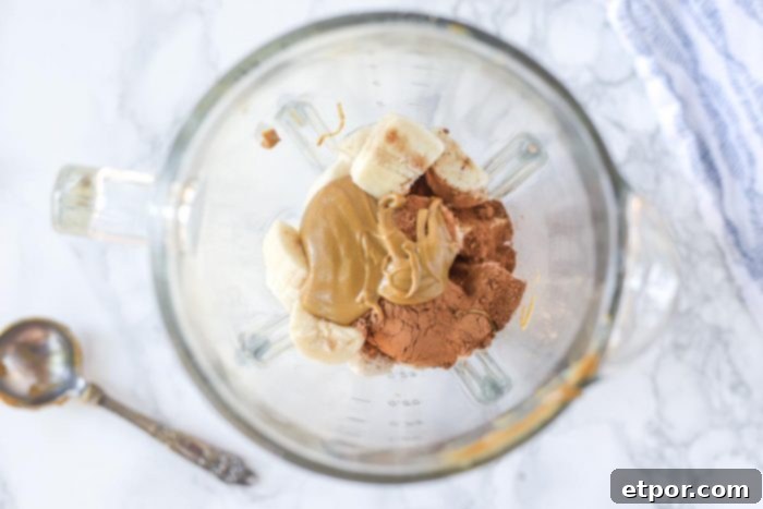 Chocolate Peanut Butter Banana Dream Freeze 7 All the ingredients - peanut butter, cocoa powder, milk, and frozen banana slices - gathered in a blender, ready to be processed into nice cream.