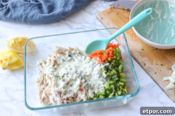 chicken, carrots, and peppers in a glass dish with mayo mixture or it to make chicken salad