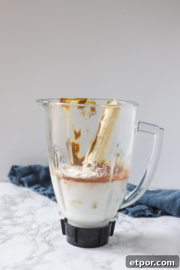 milk, cocoa powder, banana, nut butter, and cauliflower in a blender.