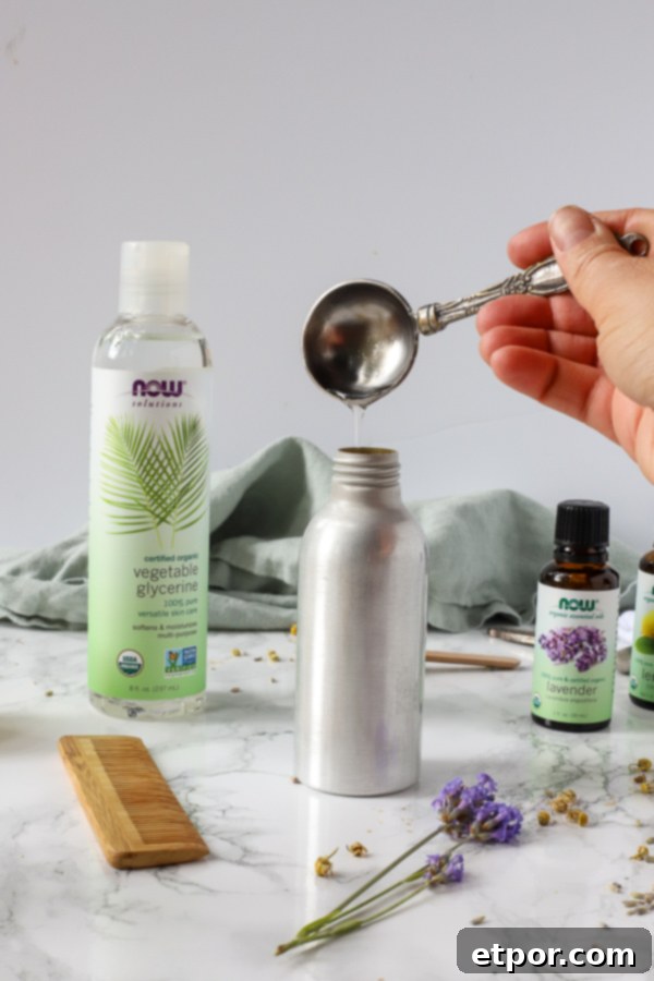 Glycerin being poured into a stainless steel spray bottle, demonstrating one of the steps in making homemade natural hair detangler.