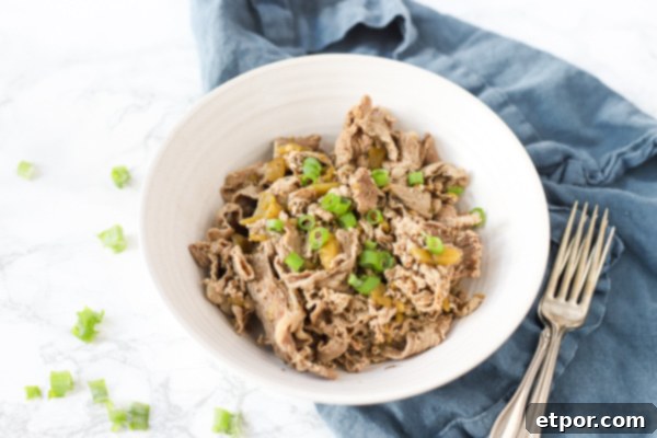 Effortless Chicago Style Italian Beef 3 Italian beef recipe in a bowl on top a blue napkin with antique forks