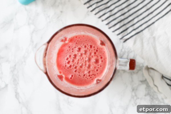 watermelon mixture in blender with a stripped towel