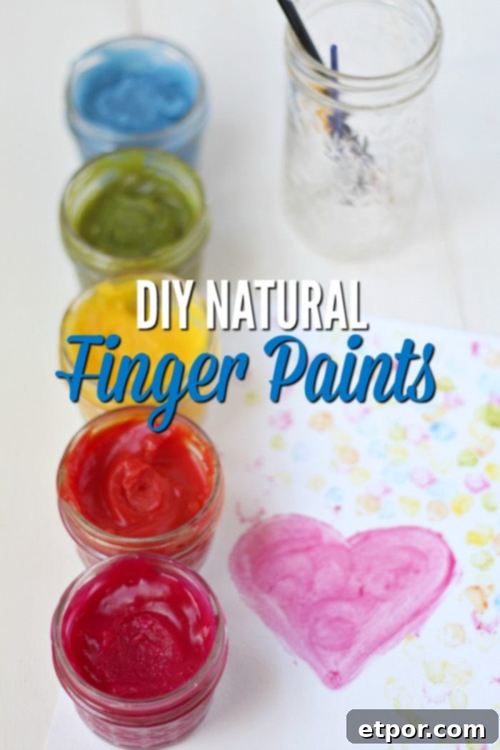 Child's hands creating art with homemade natural edible finger paints on paper.