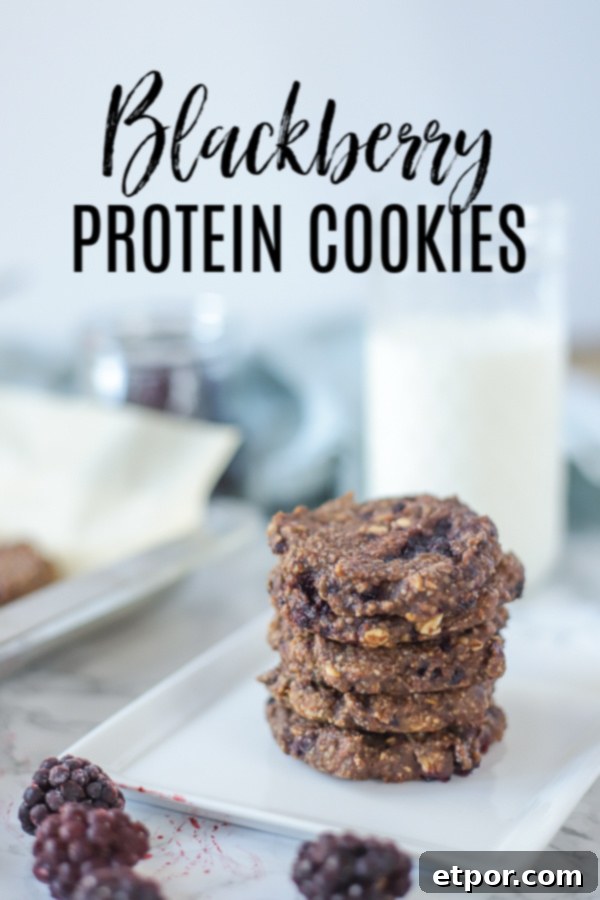 Power-Packed Blackberry Protein Cookies 2 Five blackberry protein cookies stacked on a white plate with fresh blackberries in front and a glass of milk behind it