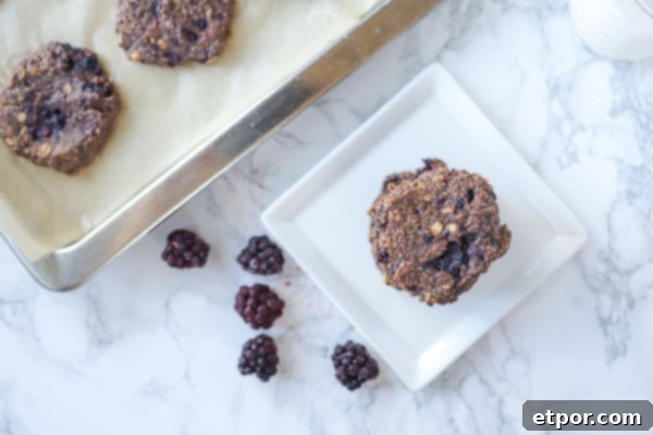 Power-Packed Blackberry Protein Cookies 3 Blue spoon mixing in frozen blackberries into a Pyrex measuring cup