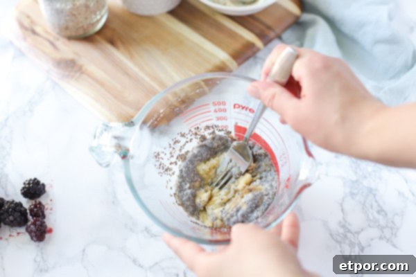 Power-Packed Blackberry Protein Cookies 6 Vegan protein powder being added to a glass measuring cup with cookie batter