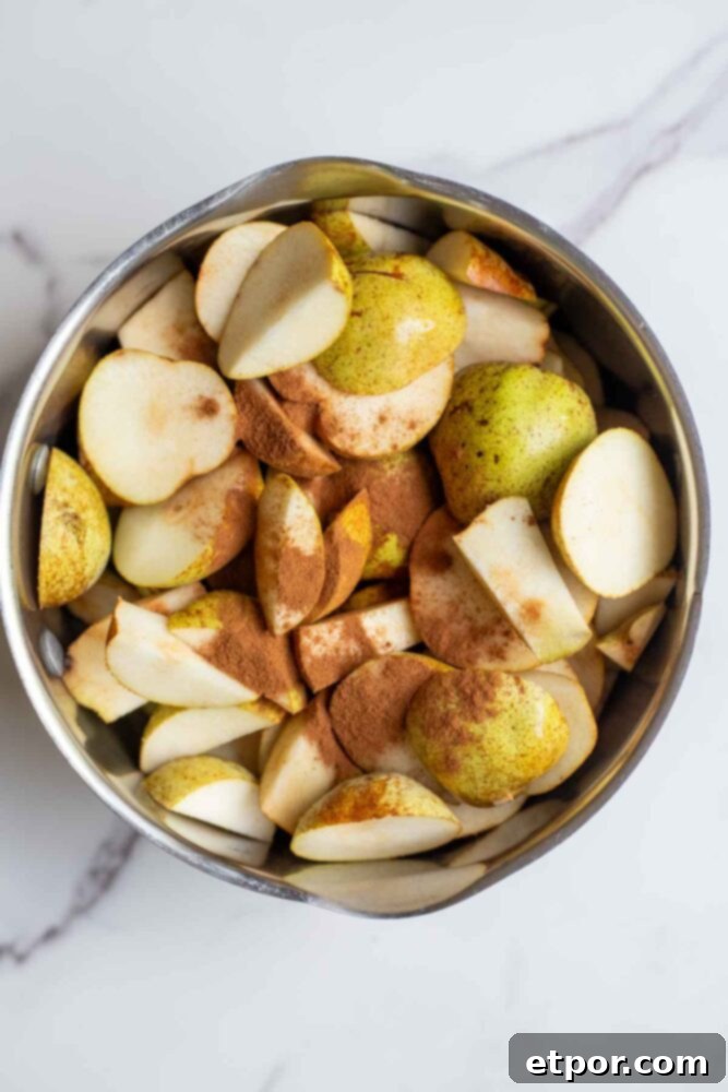 Sliced pears in a pot with water, lemon juice, vanilla and cinnamon.