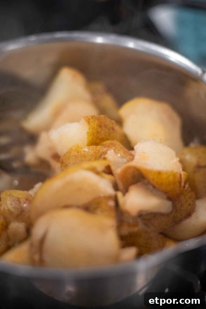 Pears cooked in a saucepan until soft.