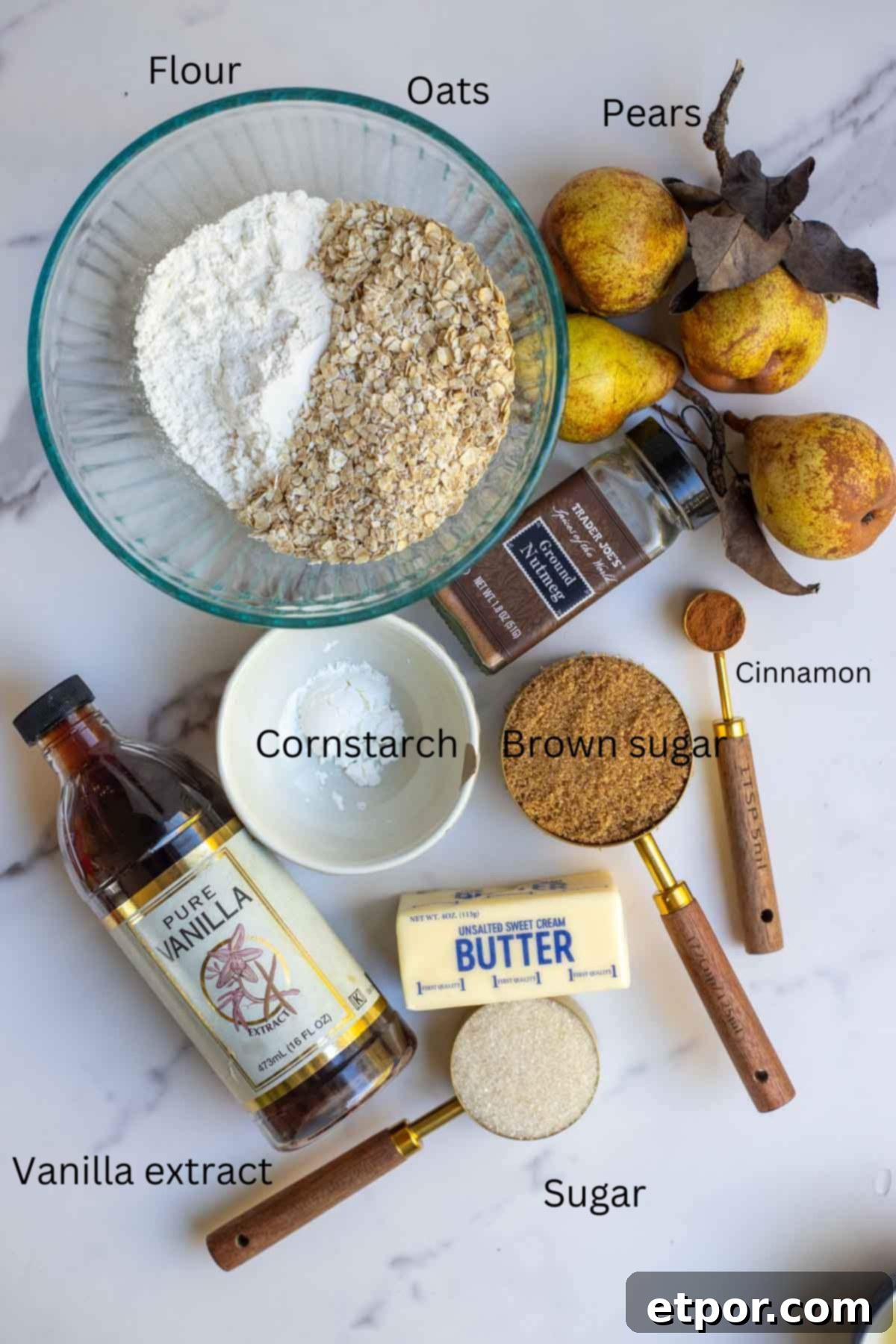 Pears, cinnamon, cornstarch, flour, oats, and other ingredients on a countertop.