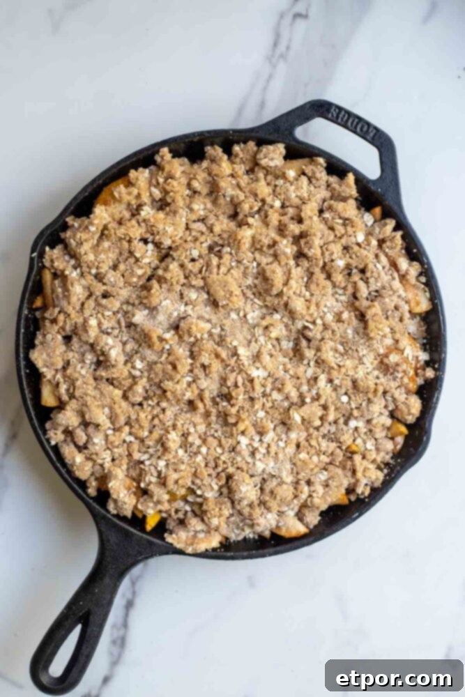 Oat crumple topping on pear filling in a cast iron skillet. 