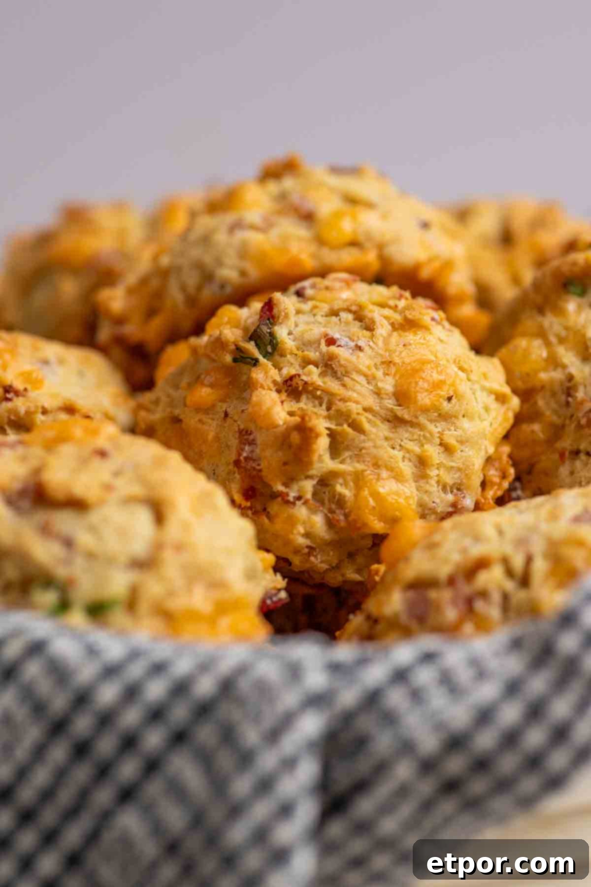 Basket of ham and cheese breakfast biscuits on a kitchen towel.
