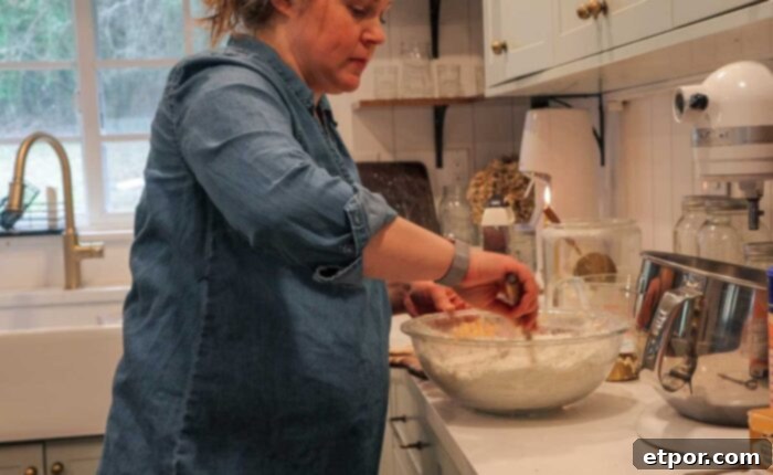 Mixing dry ingredients in a glass bowl in a kitchen setting.
