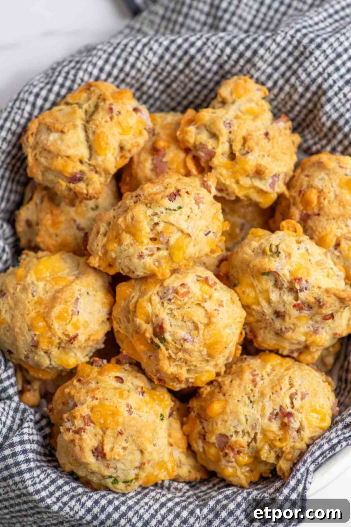 Overhead shot of a basket filled with delicious ham and cheese breakfast biscuits.